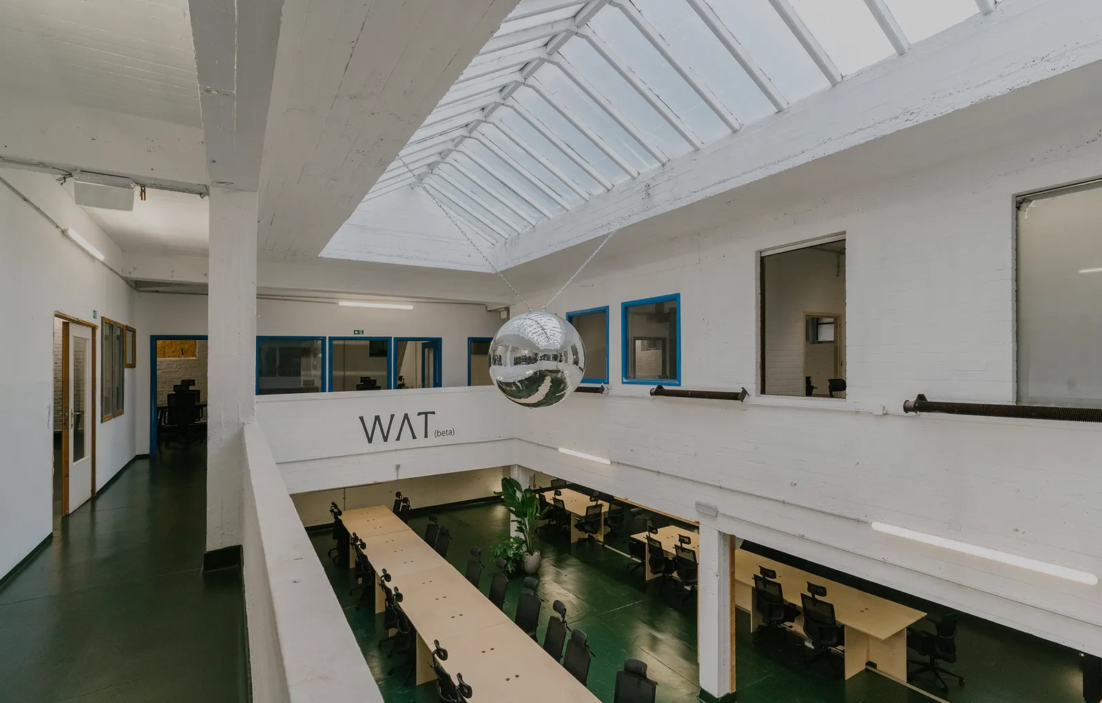 Het interieur van locatie WAT, met tafels die klaarstaan voor een bijeenkomst.